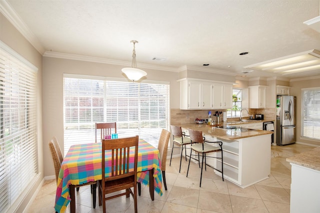 kitchen featuring a peninsula, white cabinets, stainless steel refrigerator with ice dispenser, backsplash, and crown molding