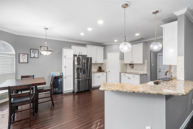 718 S Diamondhead Blvd, Crosby, TX 77532 - kitchen with stainless steel refrigerator with ice dispenser, a peninsula, dark wood finished floors, light stone counters, and white cabinetry