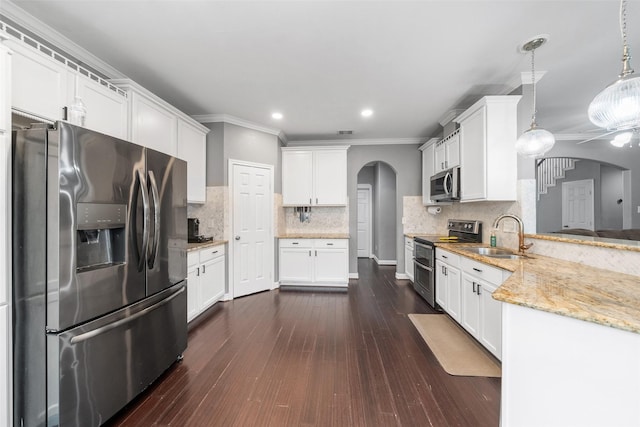 718 S Diamondhead Blvd, Crosby, TX 77532 - kitchen with stainless steel appliances, arched walkways, a ceiling fan, light stone countertops, and white cabinetry