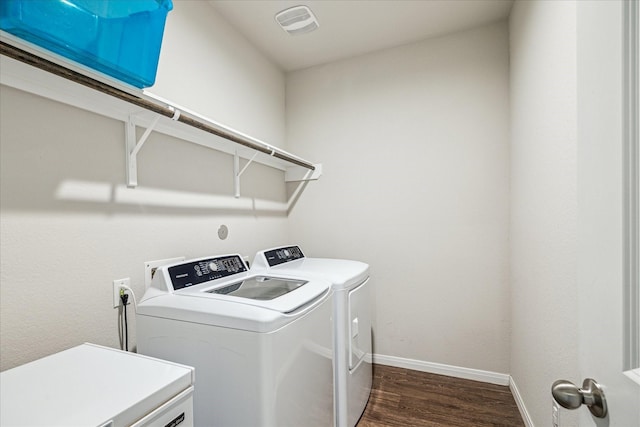 laundry area featuring baseboards, independent washer and dryer, dark wood-style flooring, and laundry area