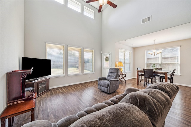 living room with baseboards, wood finished floors, visible vents, and a healthy amount of sunlight