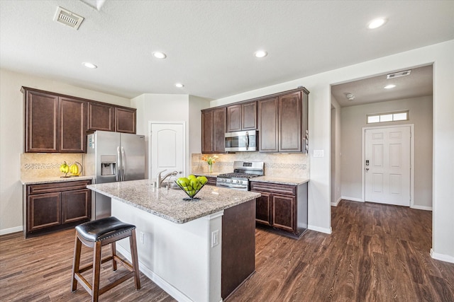 kitchen with dark brown cabinets, visible vents, appliances with stainless steel finishes, and dark wood finished floors