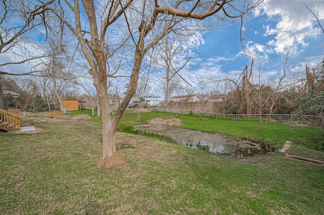 view of yard featuring a storage unit, fence, and an outdoor structure