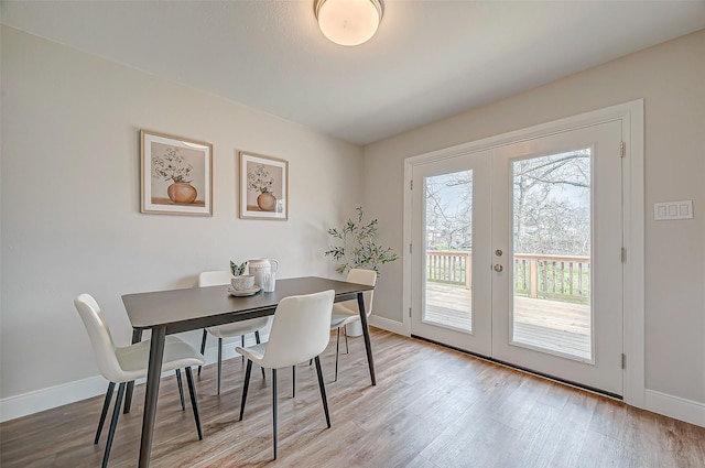 dining room with french doors, baseboards, and light wood finished floors