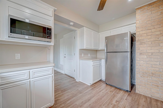 kitchen featuring stainless steel appliances, light wood-style floors, light countertops, and white cabinets