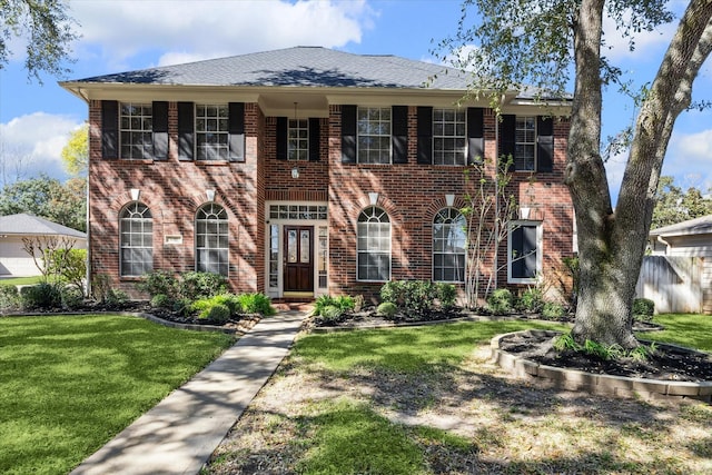 view of front of property featuring brick siding and a front yard