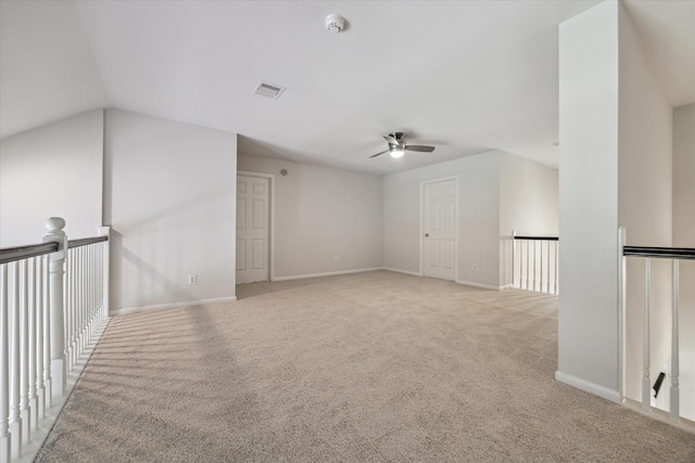 spare room with light carpet, visible vents, and baseboards