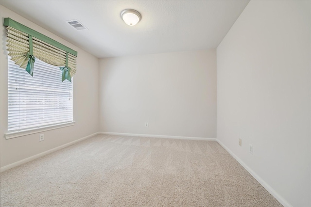 carpeted empty room featuring visible vents and baseboards