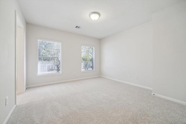 empty room featuring baseboards, visible vents, and carpet flooring