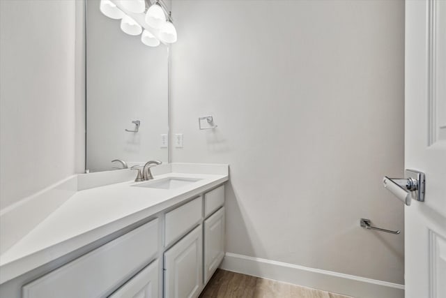 bathroom with baseboards, wood finished floors, and vanity