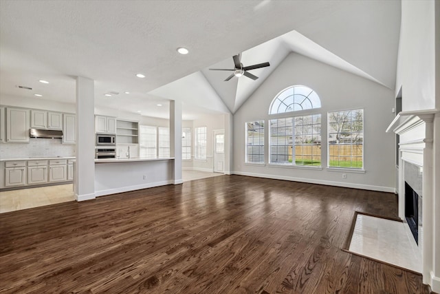 unfurnished living room with a fireplace with flush hearth, a ceiling fan, baseboards, and wood finished floors