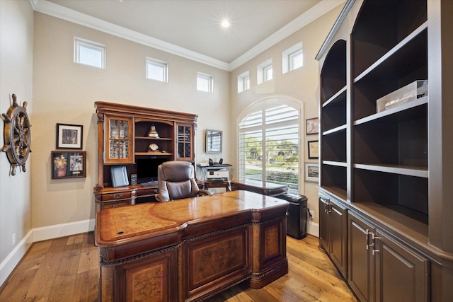 office with light wood finished floors, baseboards, ornamental molding, a high ceiling, and recessed lighting