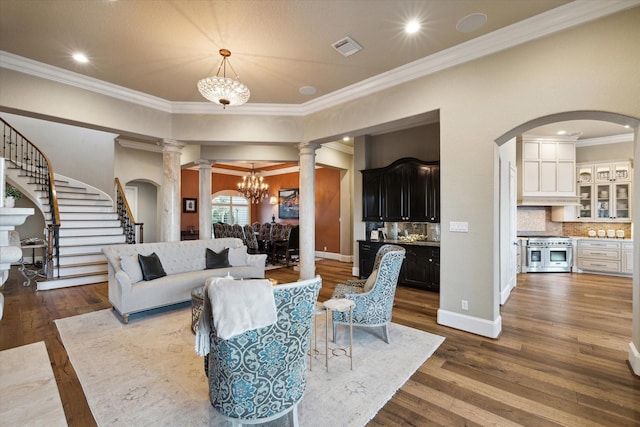 living area featuring visible vents, stairway, a chandelier, and hardwood / wood-style floors