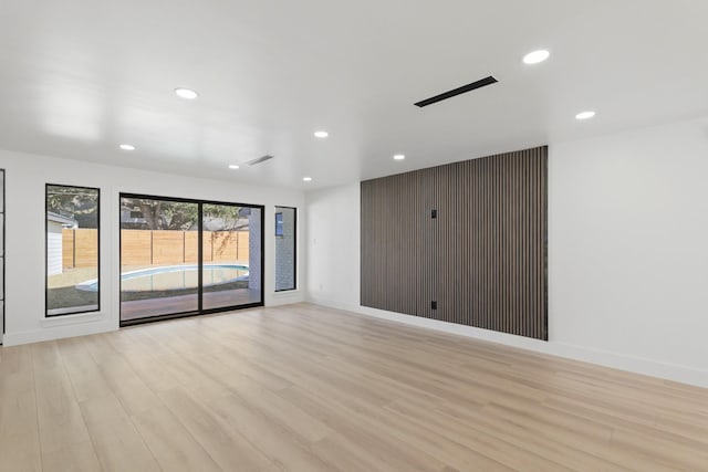 spare room featuring light wood-style floors, recessed lighting, visible vents, and baseboards