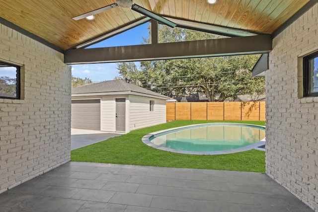 view of swimming pool featuring a yard, fence, a fenced in pool, and an outbuilding