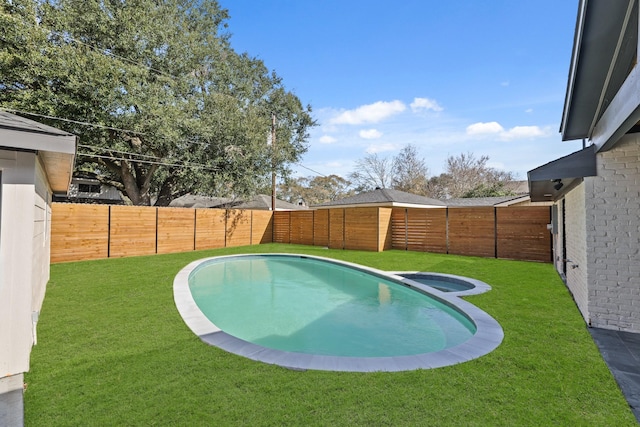 view of swimming pool with a fenced backyard, a pool with connected hot tub, and a yard