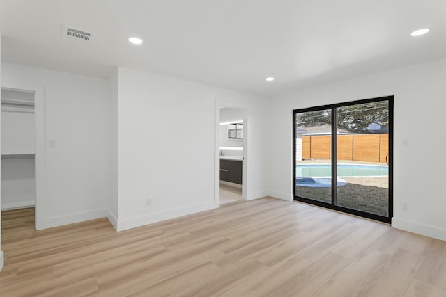 spare room featuring baseboards, light wood-type flooring, visible vents, and recessed lighting