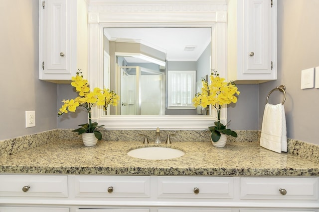 bathroom with a shower with door, ornamental molding, and vanity