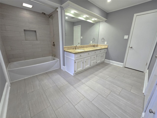 full bath with a sink, shower / bathing tub combination, baseboards, and double vanity