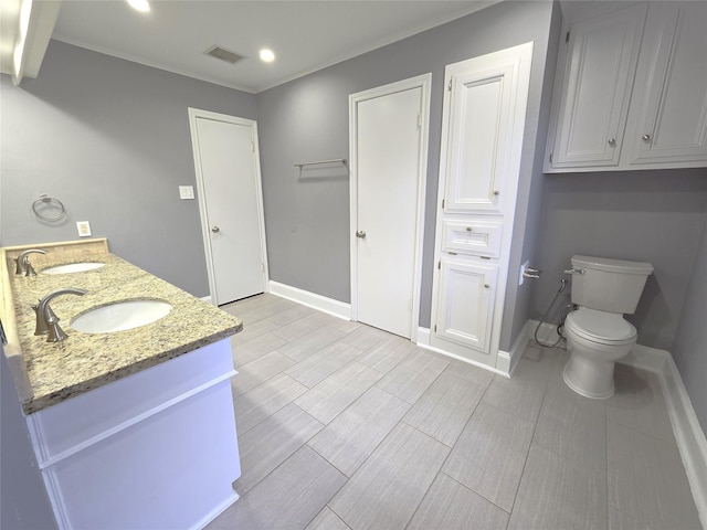 bathroom with baseboards, visible vents, and a sink