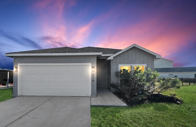 single story home with roof with shingles, concrete driveway, board and batten siding, a garage, and a front lawn