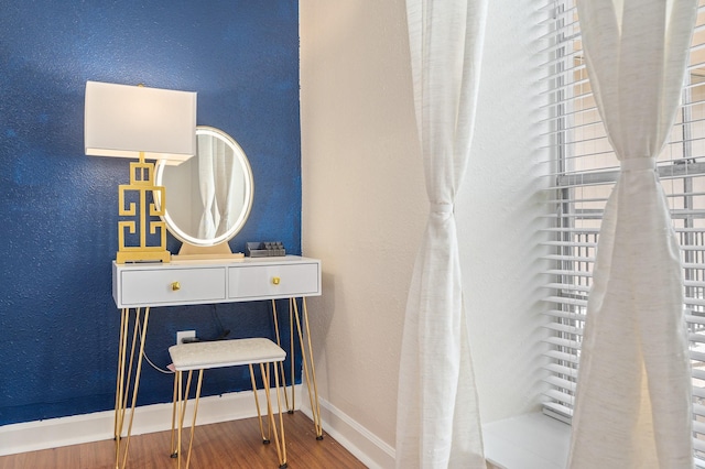 interior space featuring baseboards, wood finished floors, and a textured wall