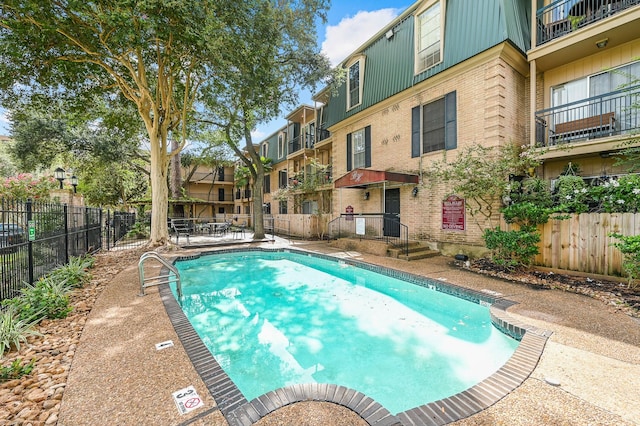 community pool with fence and a residential view