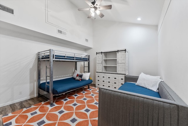 bedroom with a towering ceiling, baseboards, visible vents, and ceiling fan