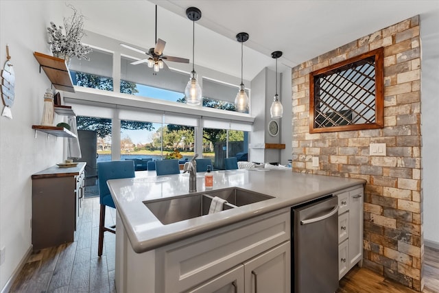 kitchen featuring ceiling fan, dark wood-type flooring, decorative light fixtures, a sink, and stainless steel dishwasher