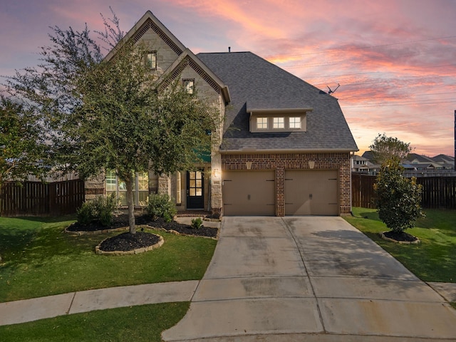 view of front of property with brick siding, fence, driveway, roof with shingles, and a front lawn