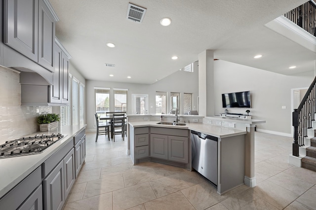 kitchen with appliances with stainless steel finishes, gray cabinets, visible vents, and a sink