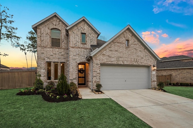 view of front of home with a garage, driveway, fence, a yard, and brick siding