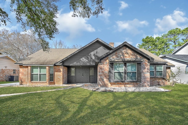 view of front facade featuring a shingled roof, a chimney, a front lawn, central AC, and brick siding