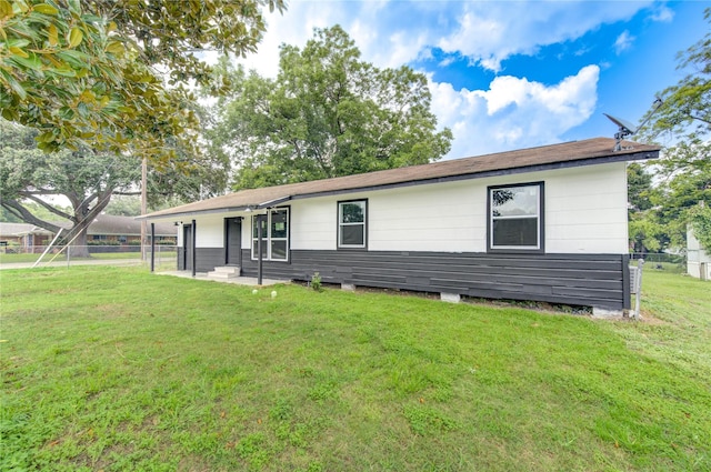 ranch-style house featuring fence and a front lawn