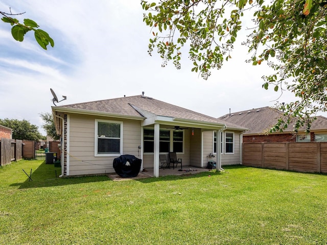 back of house featuring a yard, a patio area, a fenced backyard, and a ceiling fan