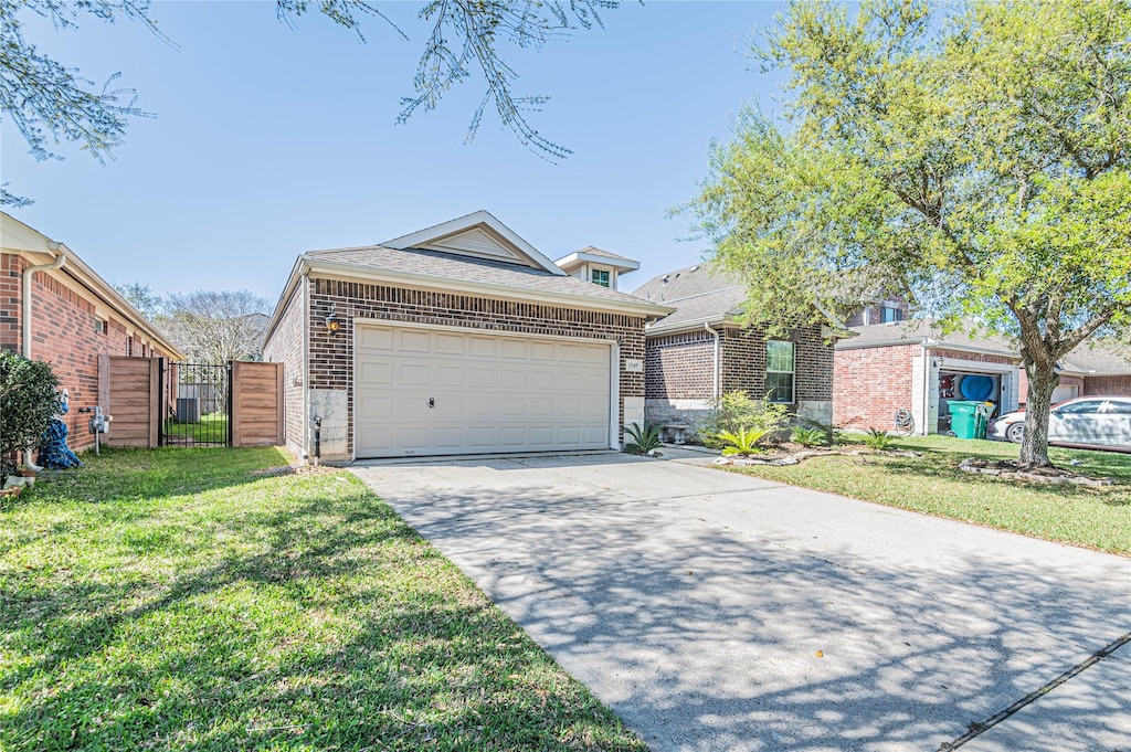2545 Blue Heron Cir, Seabrook, TX 77586 - view of front of house with a front yard, a gate, driveway, an attached garage, and brick siding