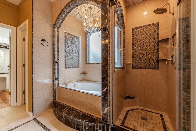 full bath with a chandelier, a garden tub, and tiled shower