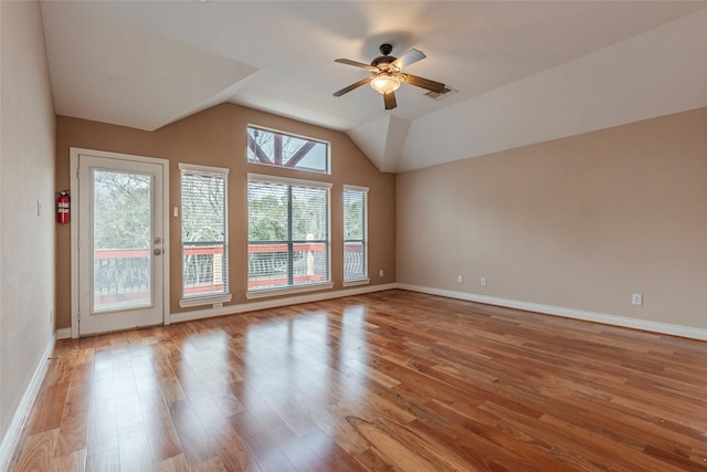 unfurnished room with ceiling fan, wood finished floors, visible vents, baseboards, and vaulted ceiling