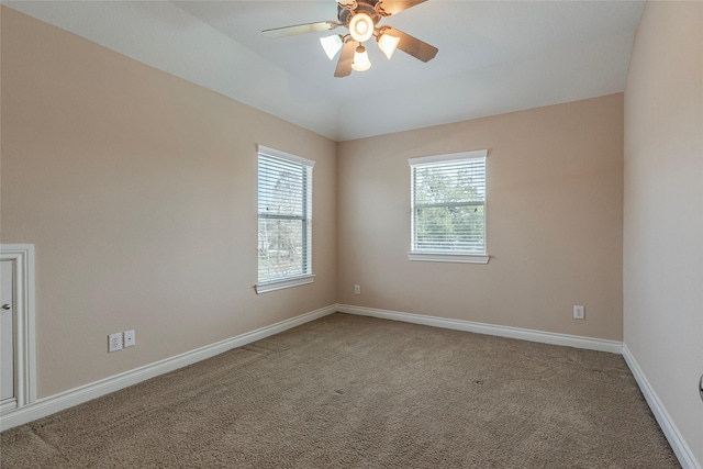 carpeted spare room with lofted ceiling, plenty of natural light, and baseboards