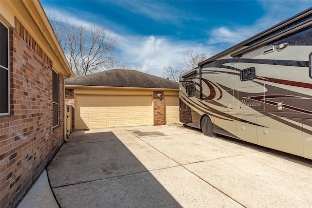 view of home's exterior with a garage, driveway, and brick siding