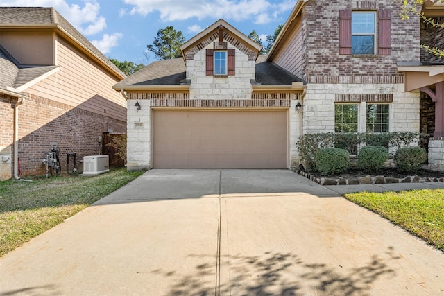 view of front of property featuring driveway, stone siding, roof with shingles, an attached garage, and brick siding