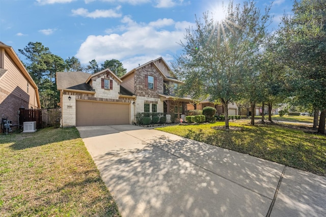 view of front of home with an attached garage, fence, stone siding, driveway, and a front lawn