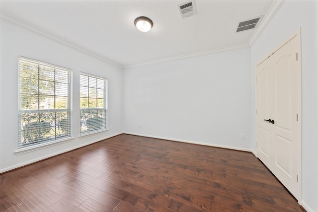 empty room with visible vents, dark wood-type flooring, and crown molding