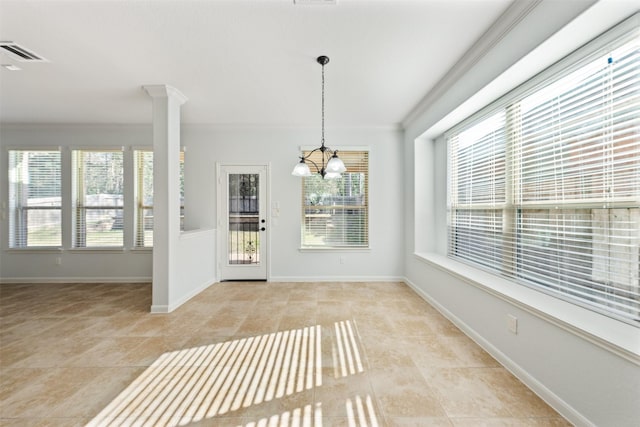 interior space featuring a notable chandelier, visible vents, baseboards, ornamental molding, and decorative columns