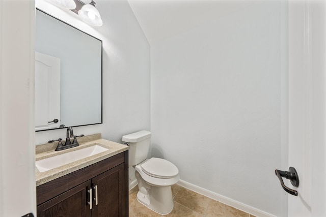 half bathroom featuring toilet, tile patterned flooring, baseboards, and vanity