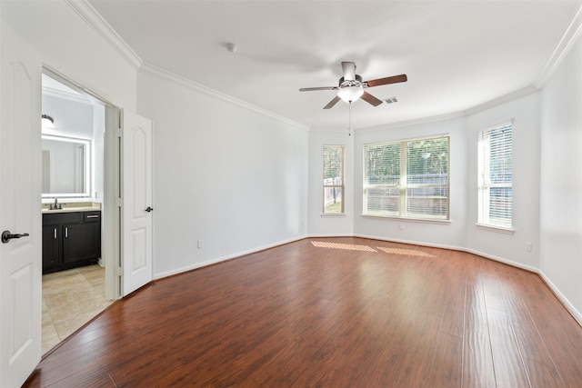 empty room with ornamental molding, light wood-type flooring, and visible vents