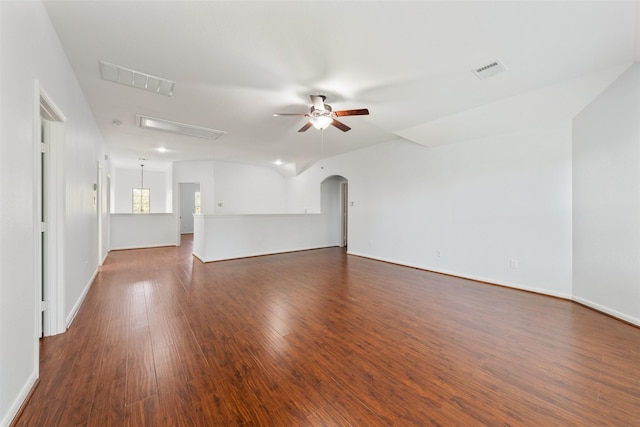 unfurnished living room with arched walkways, visible vents, dark wood-style flooring, and a ceiling fan