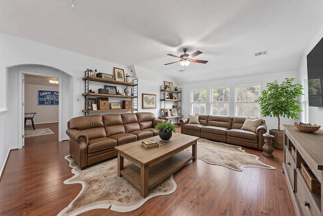 living room with arched walkways, lofted ceiling, wood finished floors, visible vents, and a ceiling fan