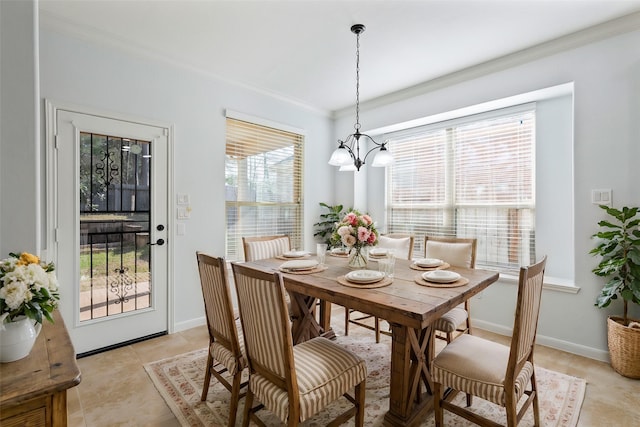 dining room with an inviting chandelier, baseboards, crown molding, and light tile patterned flooring