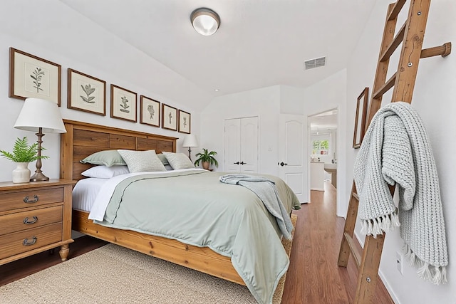 bedroom with baseboards, a closet, visible vents, and wood finished floors